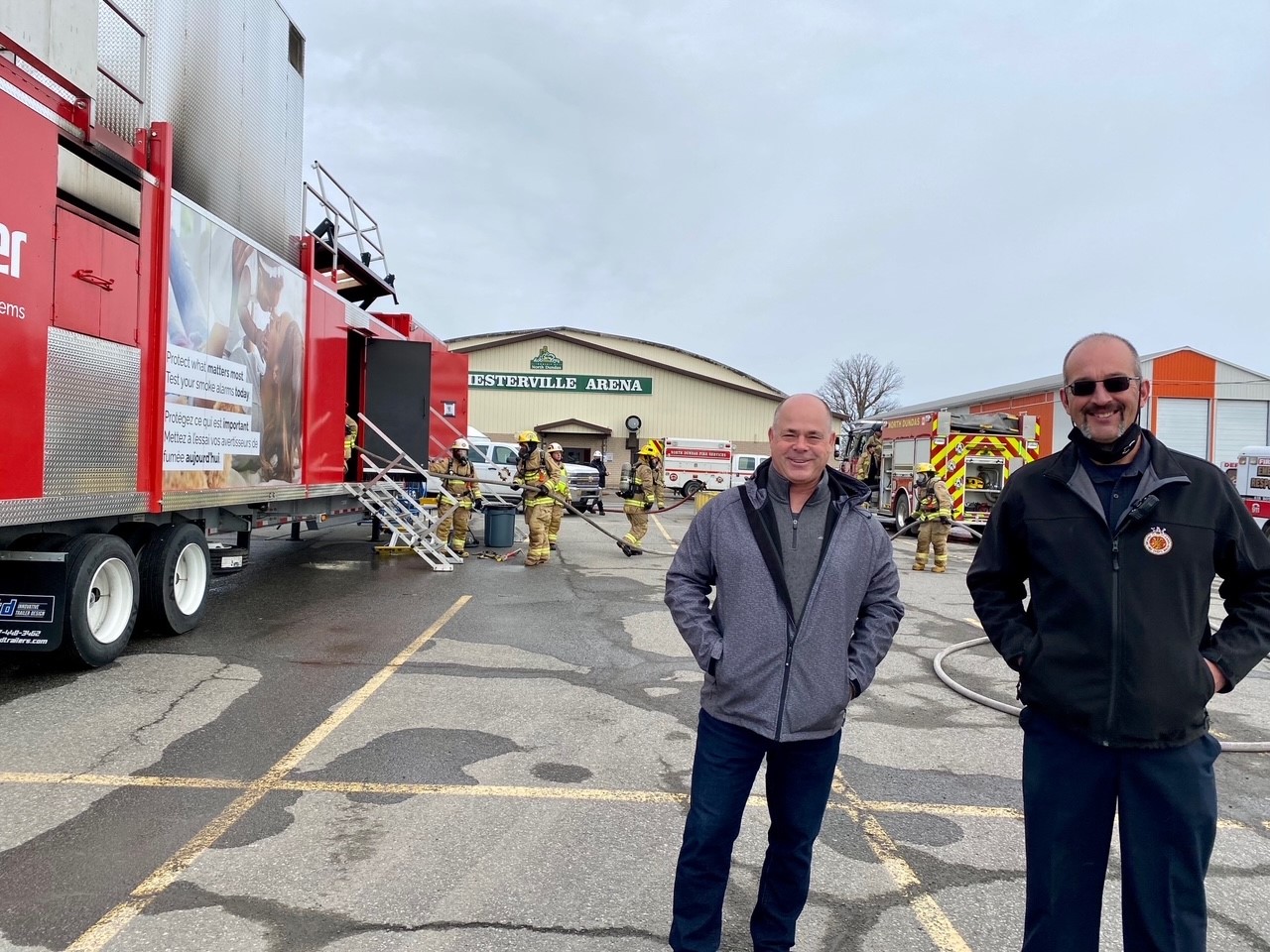 Mayor Fraser and Fire Chief Mike Gruich standing in front of red fire training trailer 