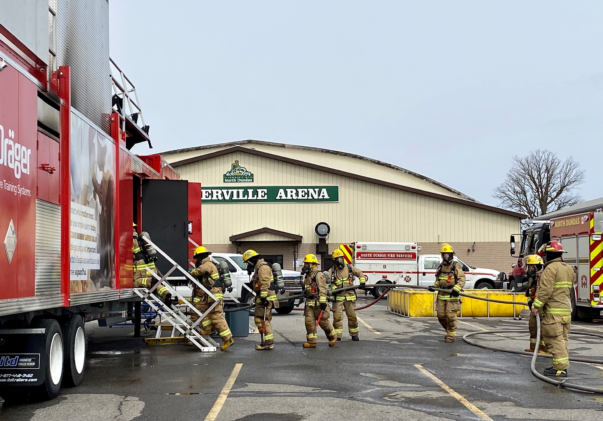 Firefighters entering red fire training trailer