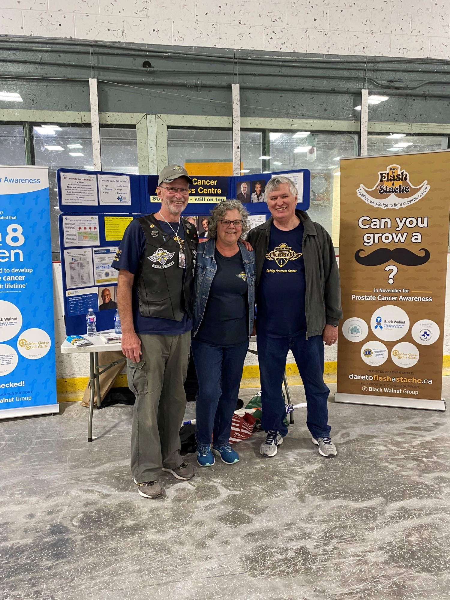 ride for dad participants standing a vendor booth in arena