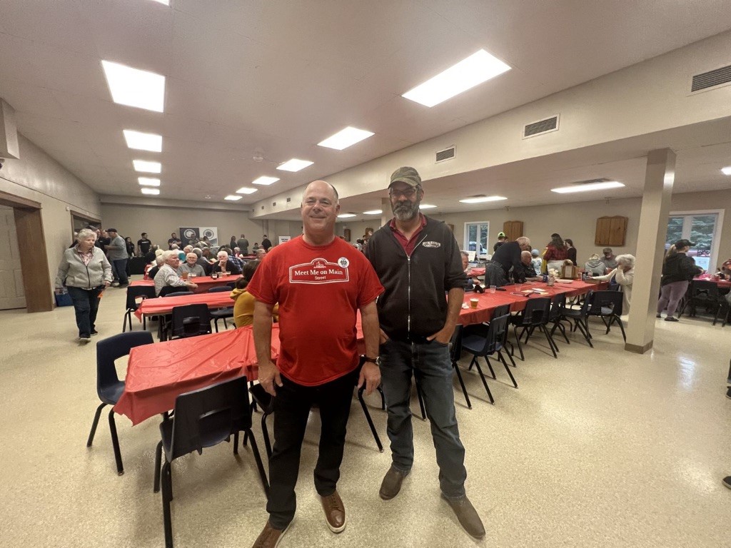 Mayor and guest standing by table