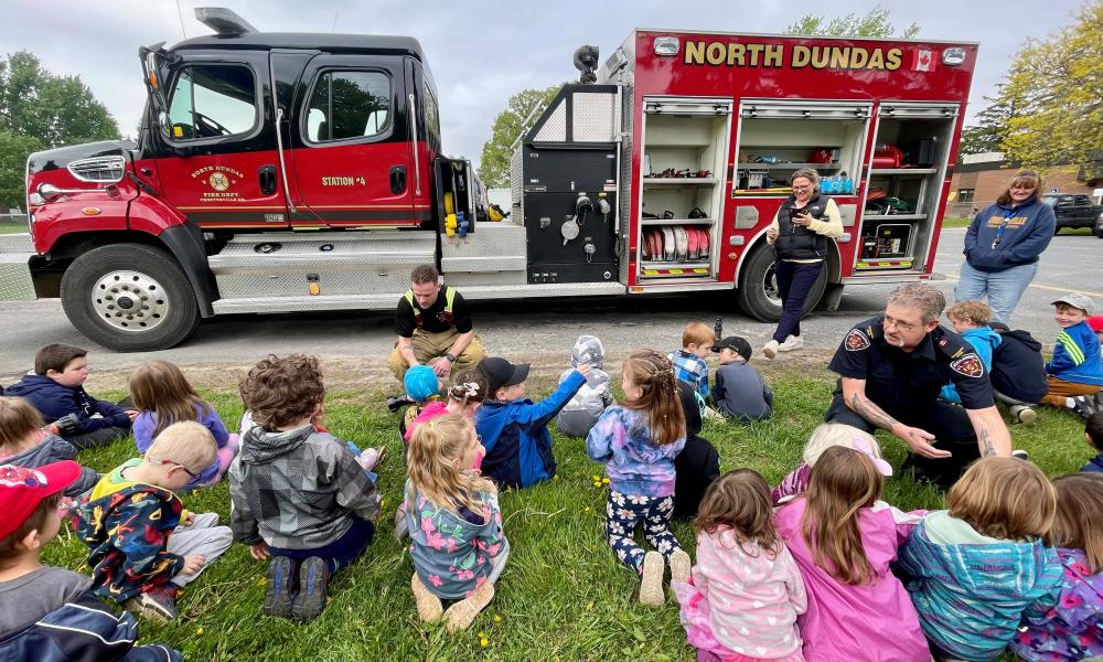 children with firefighters and fire truck