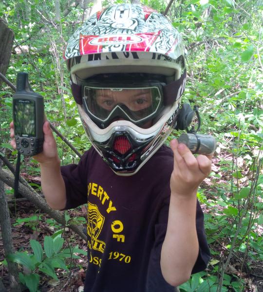 geocacher with helmet in forest