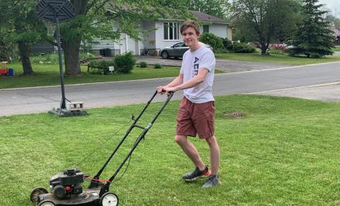 Isaac mowing a lawn in Chesterville