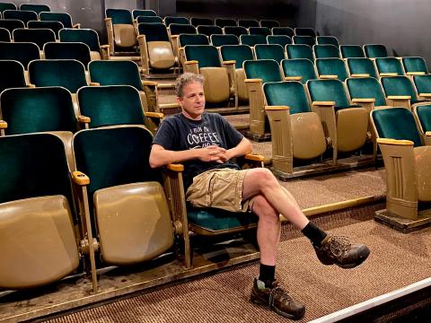 Aaron Dellah sits in the Old Town Hall theatre, silently contemplating adjustments needed to achieve perfection with the audio visual equipment. 