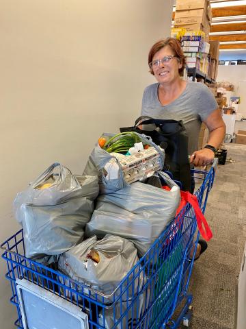 Kim Merkley pushes a cart loaded with food for one of the many families that rely on the food bank every month. 