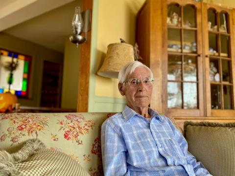 Bud Raistrick sits in his living room.