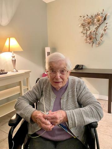 Edith Baker busies herself knitting a dish cloth while chatting about her life. 