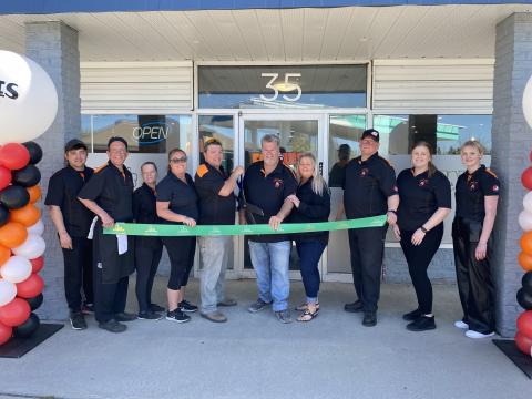 Grand opening photo of Fat Les's staff in front of store