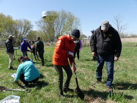 person in red jacket planting tree