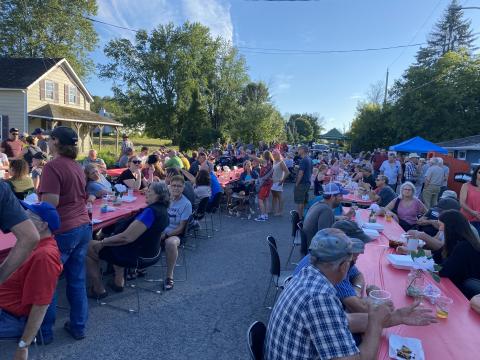 People eating at tables on the street for MMOMS