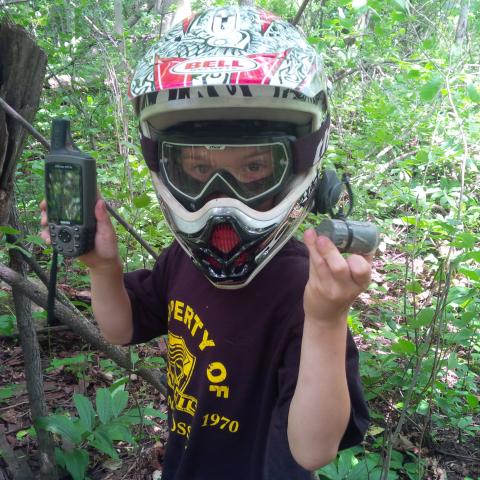 geocacher with helmet in forest